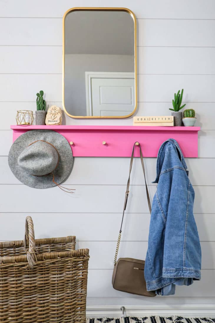 pink wall-mounted coat rack with ledge for miscellaneous small items