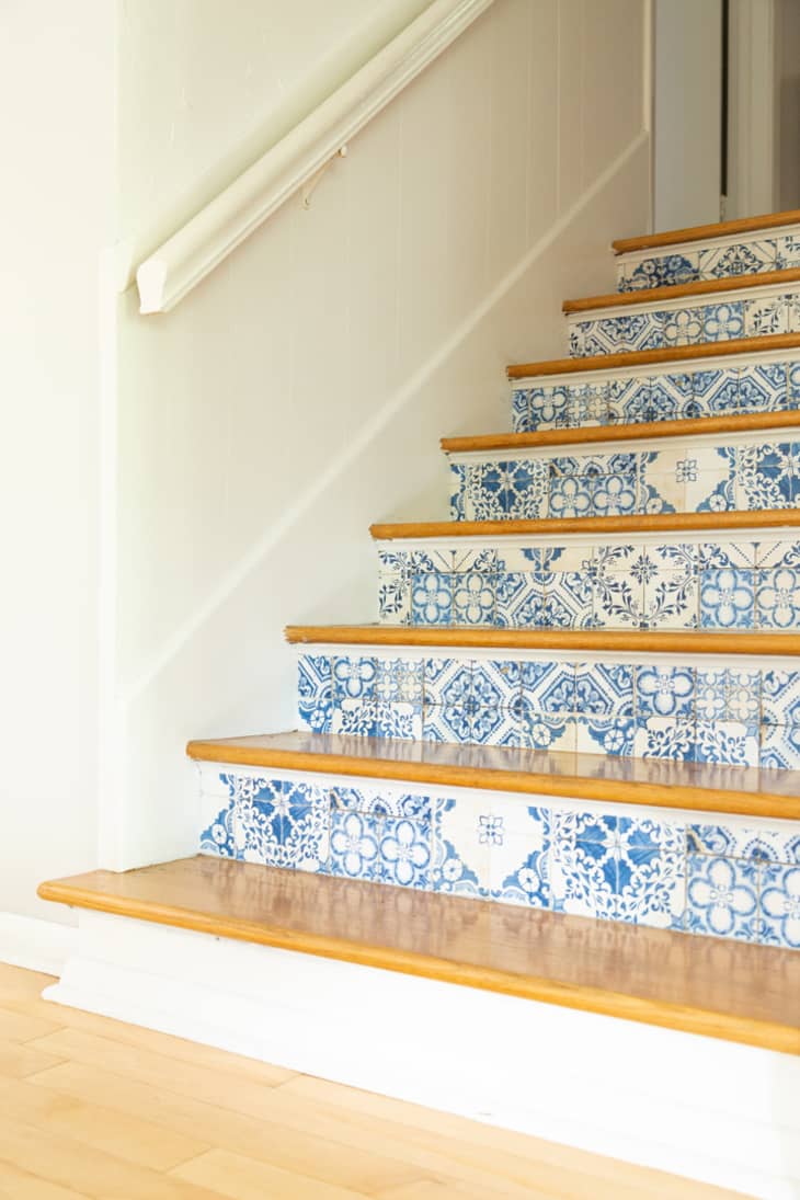 stairs with blue and white patterned wallpaper on the risers