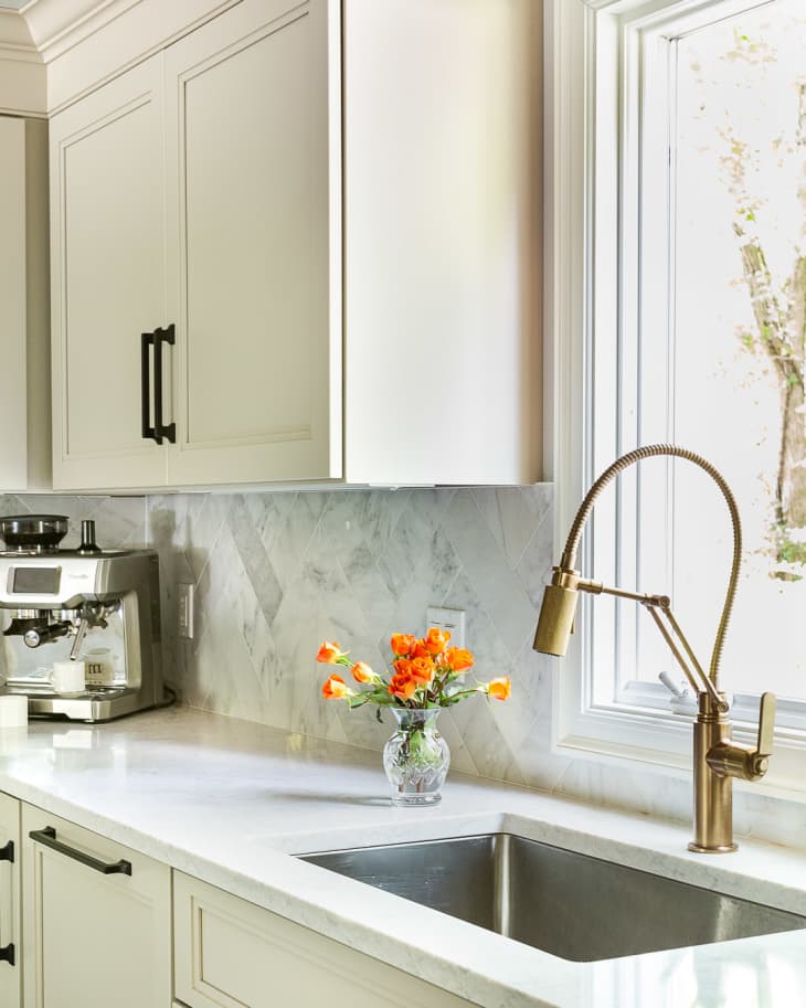 white kitchen cabinets with hardware and faucets in mixed metal tones