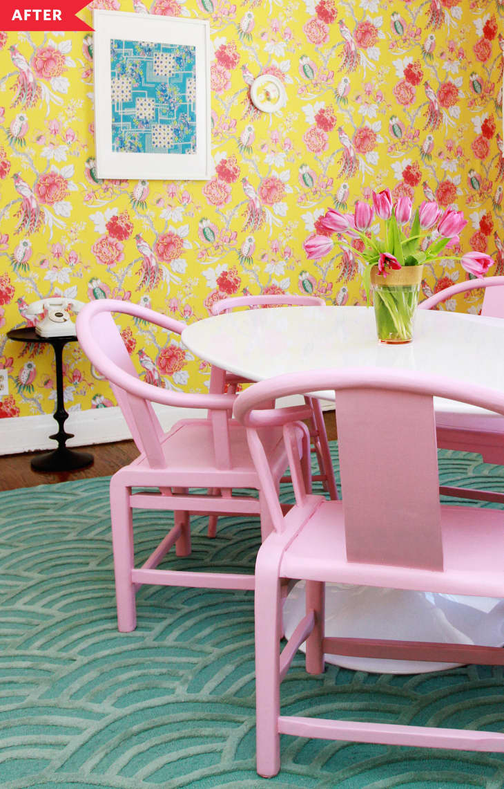 After: dining room with yellow floral wallpaper, white oval table, and pink chairs and pink light fixture