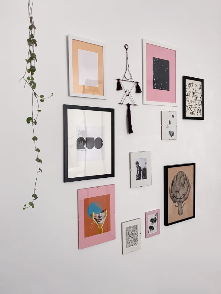 gallery wall featuring art with various colored mats