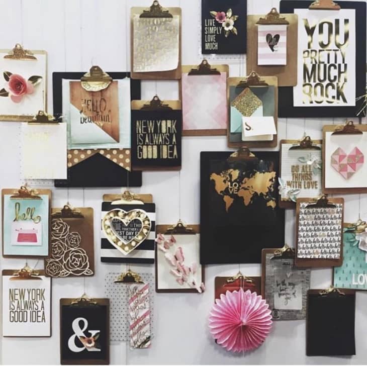 wall of art displayed using clipboards
