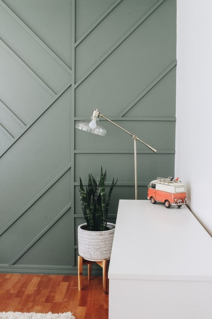 green wall with geometric wood trim accent