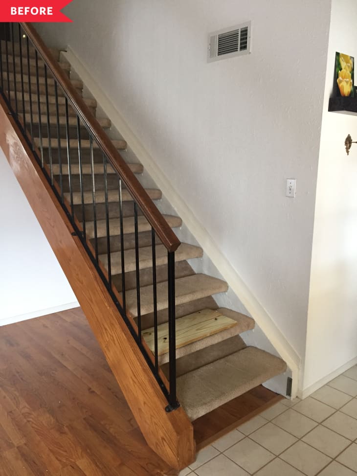 Before: Dim brown-carpeted stairs with wood railing
