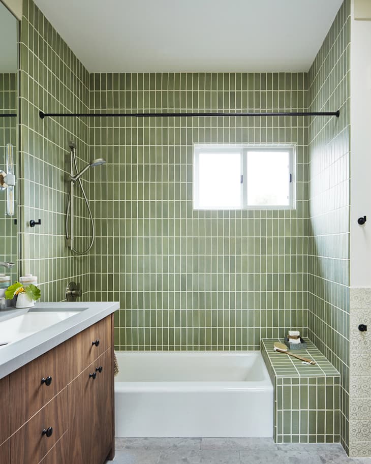 bathroom with green vertical tile and brown wood vanity