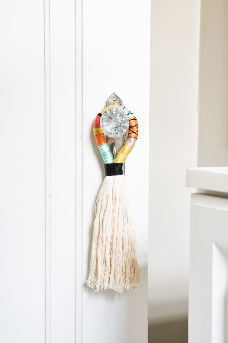 closet door with glass knob, decorated with fringed tassel