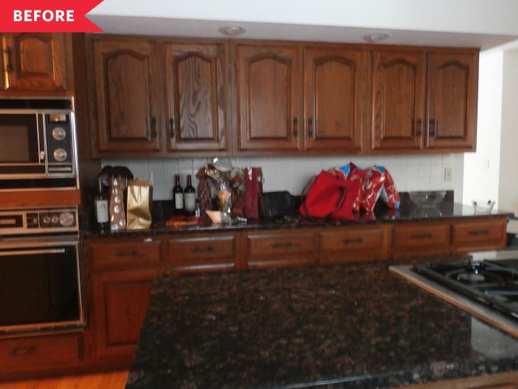 Before: Kitchen with dark wood cabinets, black stone counters, and outdated appliances