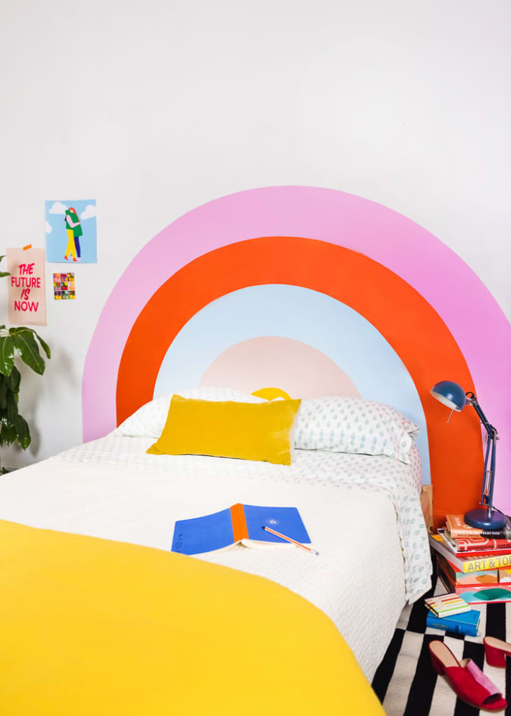Rainbow painted behind bed in colorful and bold bedroom