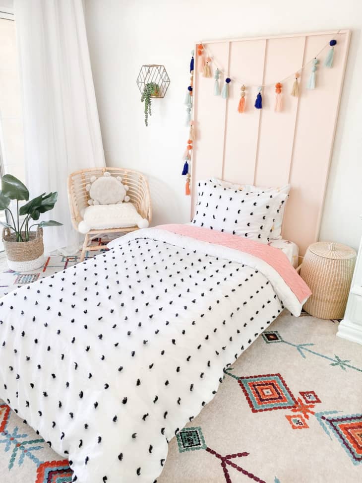 Light pink wooden headboard in colorful kid's room