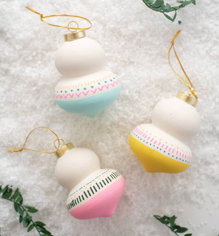 White hourglass-shaped ornaments with pastel paint and doodles on bottom