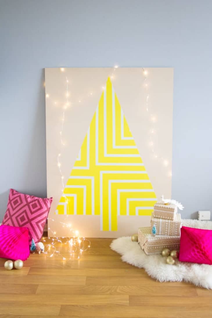 Bright yellow Christmas tree painted on plywood