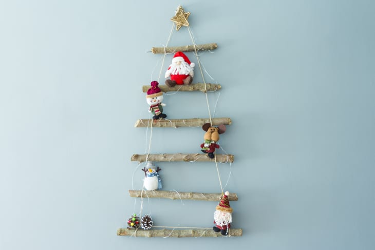Homemade wall-mounted Christmas tree crafted from branches and rope