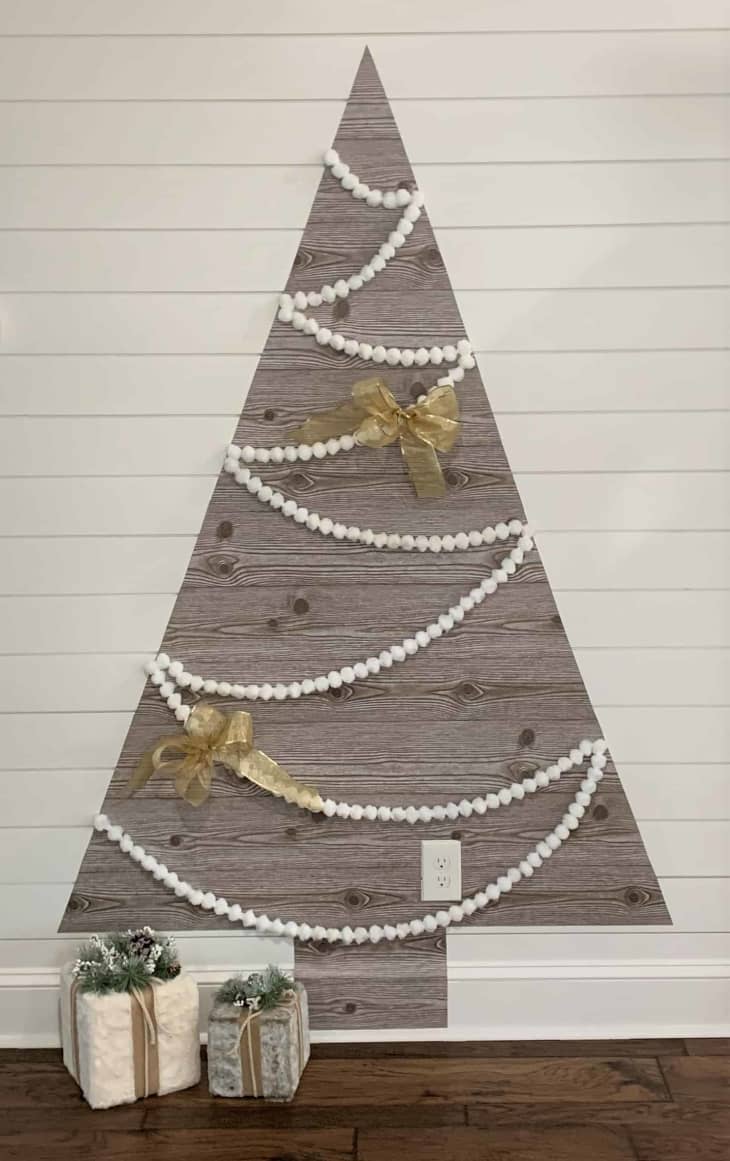 Decal wall Christmas tree made with shelf paper and decorated with garland and bows