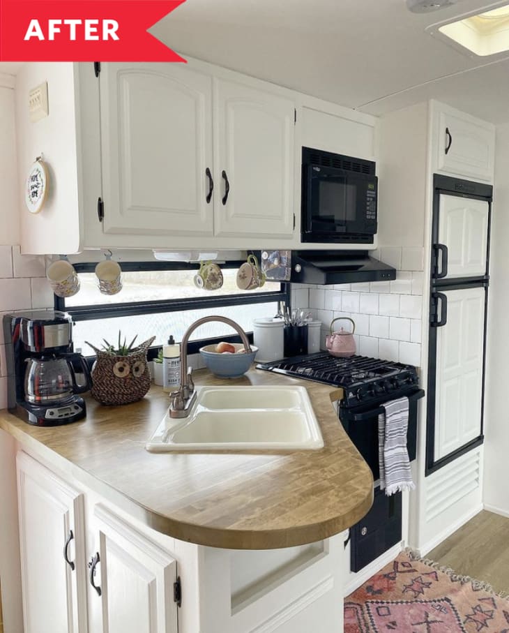 After: Kitchen in camper with white cabinets and black appliances