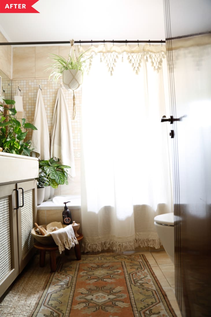 After: boho bathroom with cane vanity, tasseled shower curtain, and patterned rug