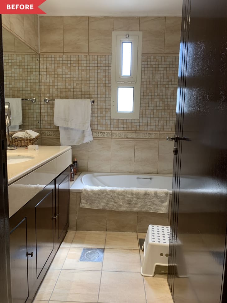 Before: bathroom with beige travertine tile and dark brown vanity