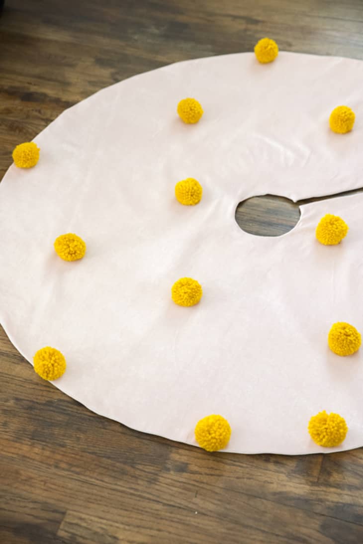tree skirt dotted with yellow pom poms