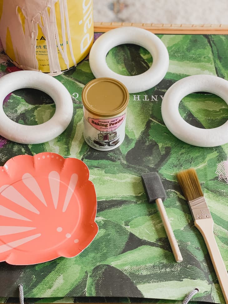 paint, baking powder, foam brushes, paint tray, and foam rings on a table