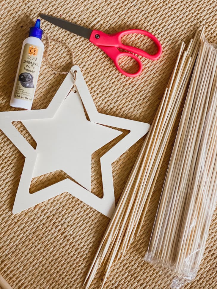 wood star ornament, glue, scissors, and bamboo skewers