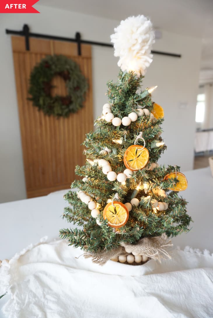 tree decorated with dried clementines, wood bead garland, and a pom pom tree topper
