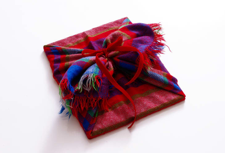 gift wrapped in a plaid scarf and tied with a bow