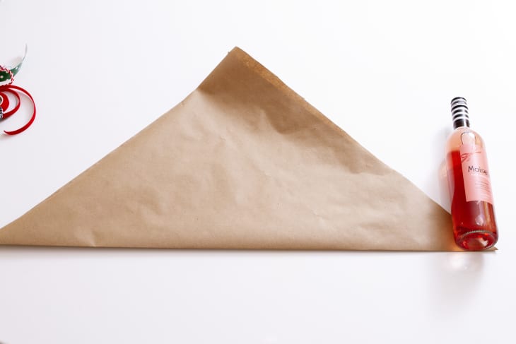 paper folded into triangle shape with wine bottle on right side