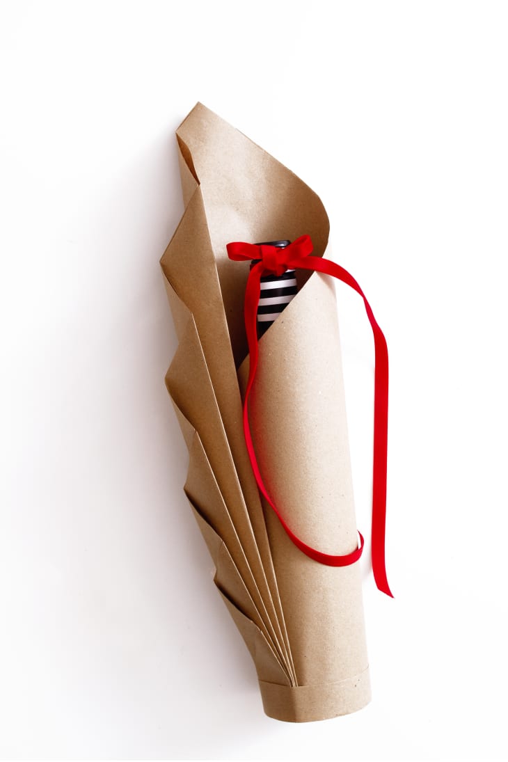 wine bottle wrapped in brown paper with a red ribbon