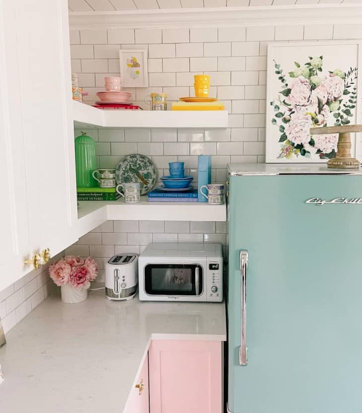 Kitchen with sky blue fridge and shelves with colorful books and dishes