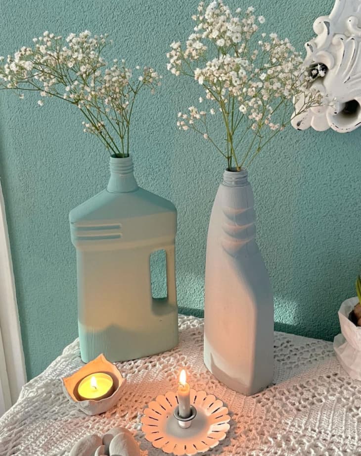 Cleaning containers painted with matte teal and gray holding flowers