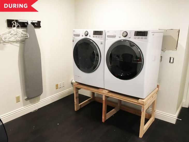 During: white laundry room with raised washer and dryer