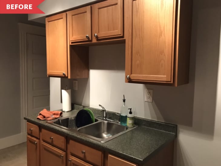Before: Brown wood cabinets and small sink in kitchen