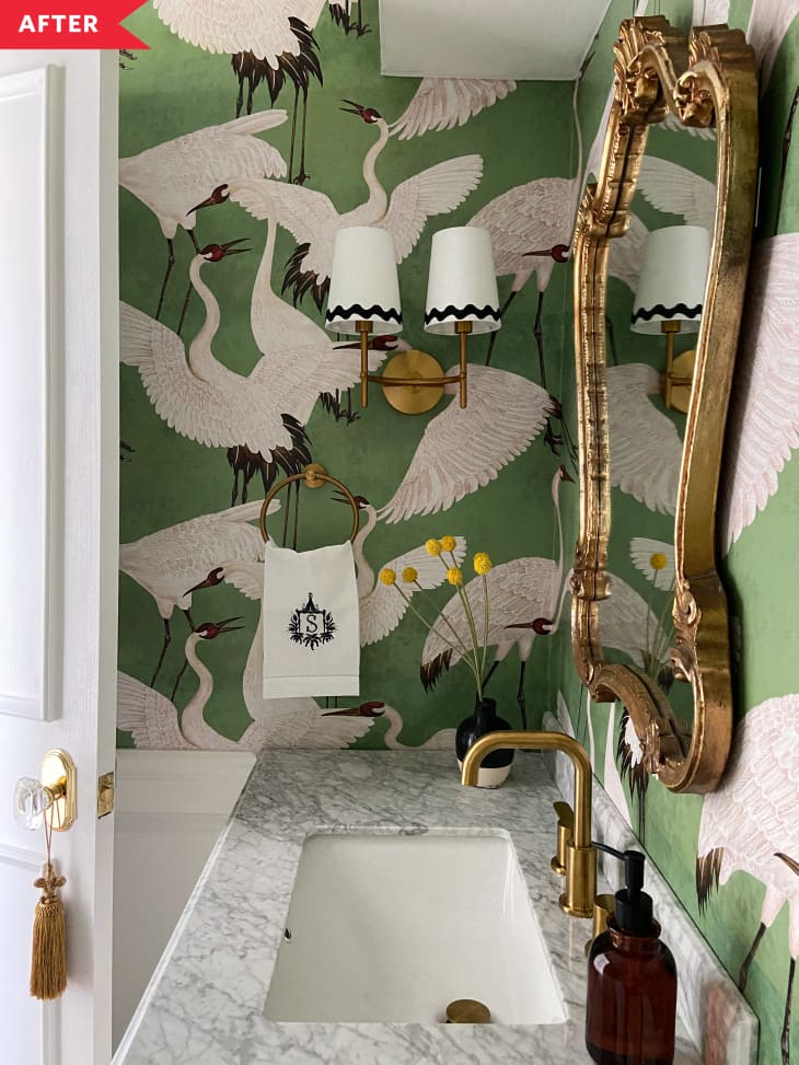 After: Bathroom with green crane wallpaper, marble-topped vanity, and gold mirror