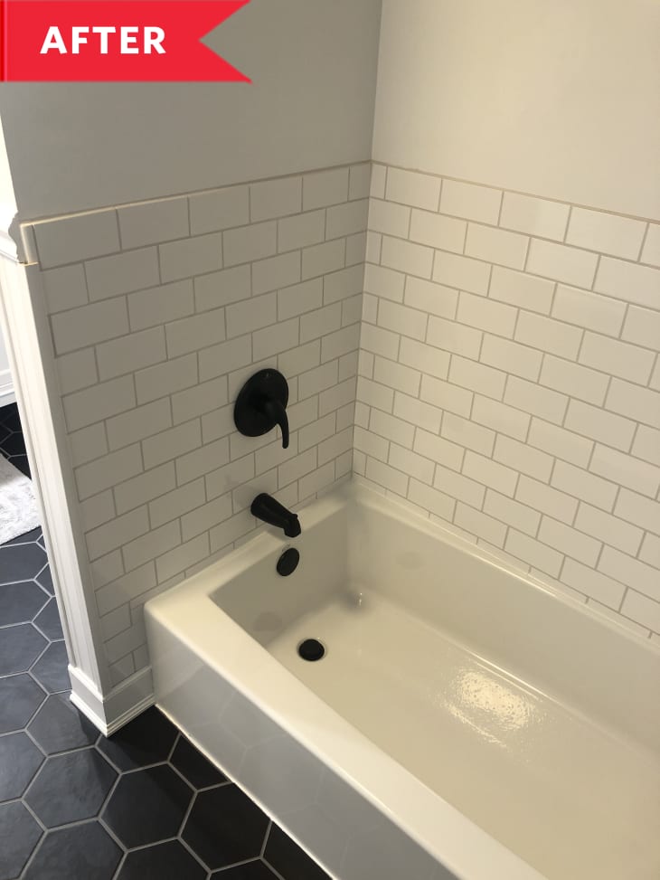 After: New white bath tub framed by white subway tile