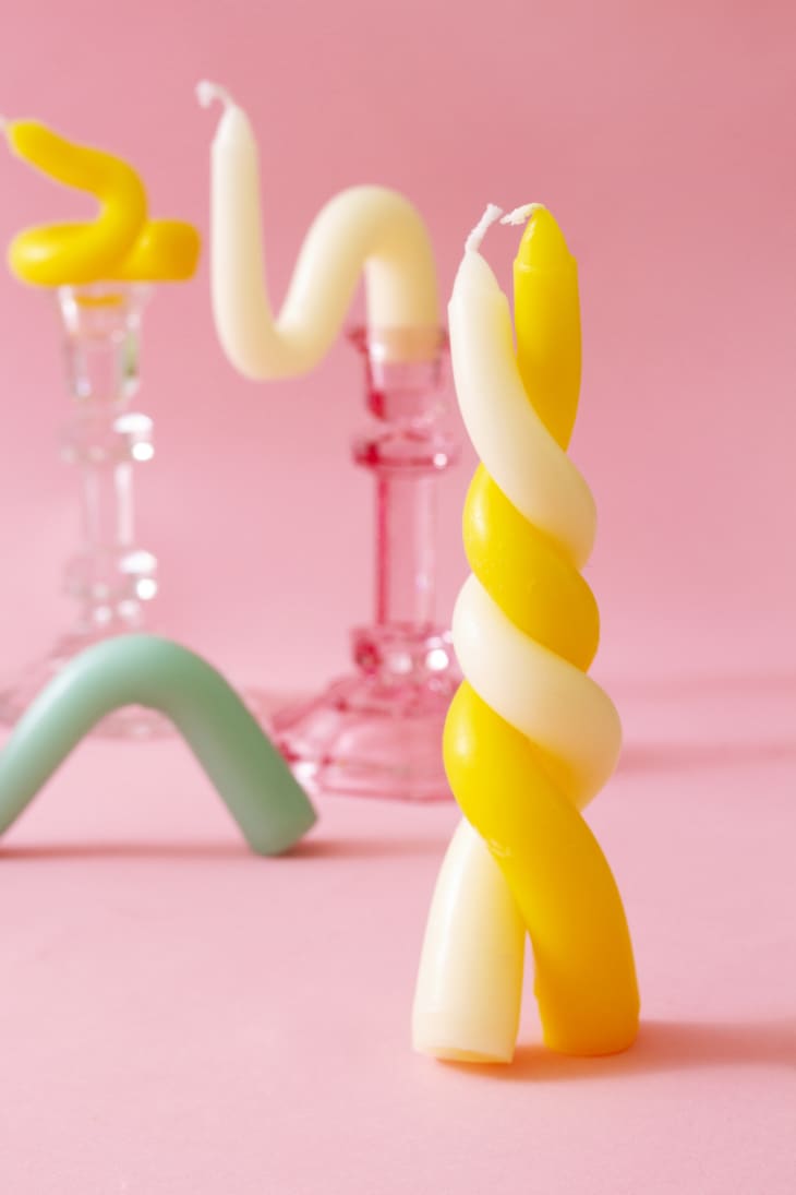 various bendy candles displayed on a flat surface or in candlesticks