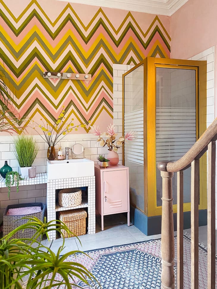 Bathroom with chevron walls and standing shower with gold frame