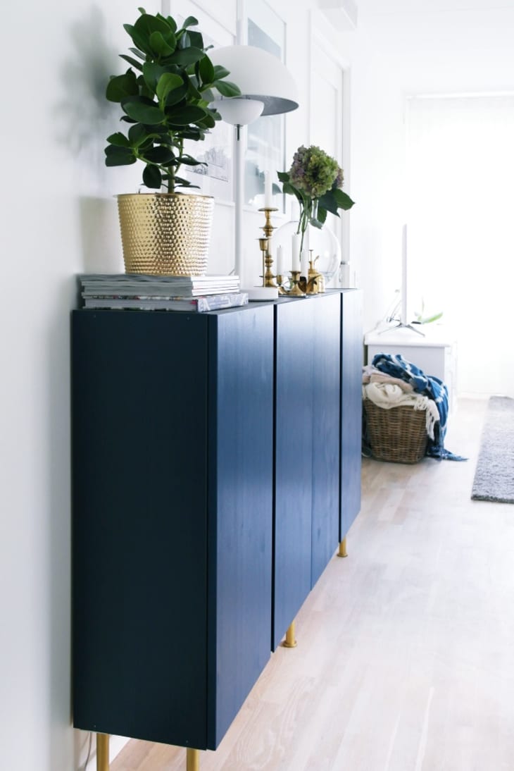Dark painted IVAR cabinets with mid-century modern legs and plants on top