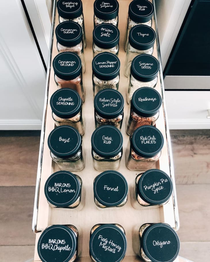 drawer with spice jars that are labeled on the tops