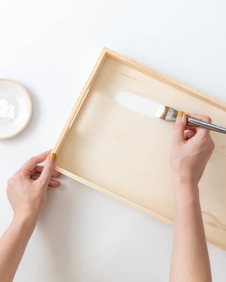 Hands painting wooden tray white