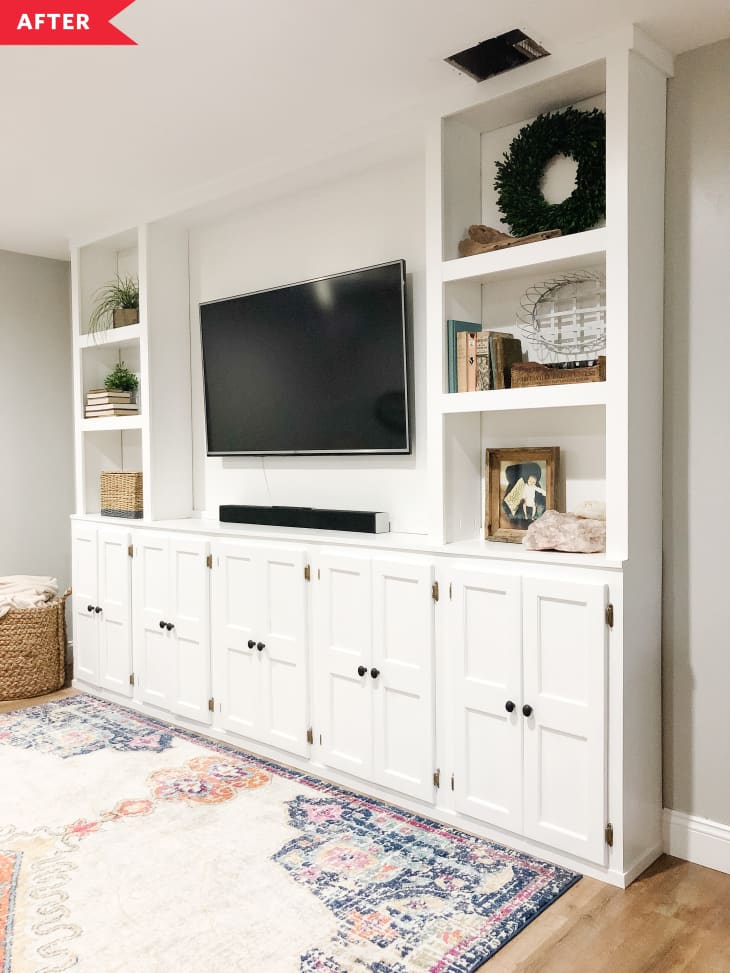 After: White built-ins with cabinets and shelves, surrounding a TV