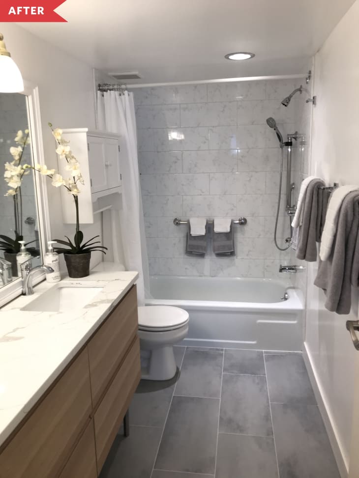 After: Bathroom with oversized gray tile floor, wood vanity, and white walls