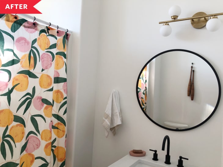 After: White bathroom with black mirror and brass vanity light