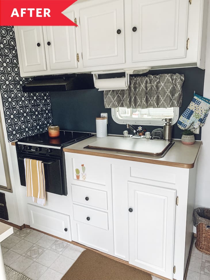 After: RV kitchen with white cabinetry, painted backsplash, and stenciled feature wall