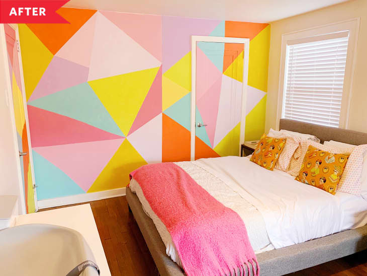 床旁边的墙上有明亮的粉红色，黄色，蓝色和橙色的壁画