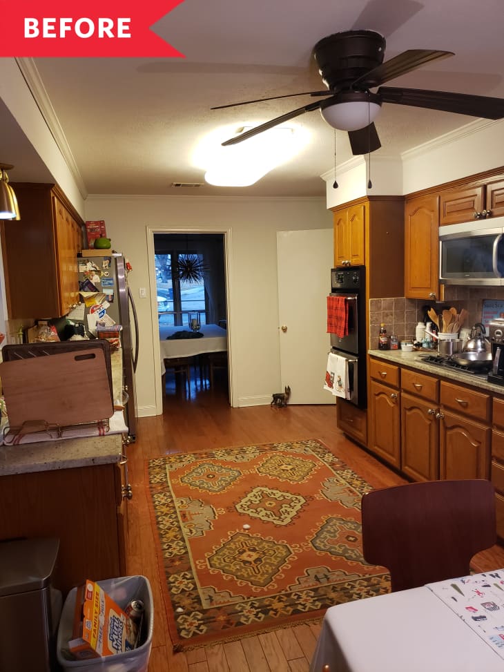 Before: Kitchen with counters and cabinetry along walls, large ceiling fan, and rust-colored kilim rug in center