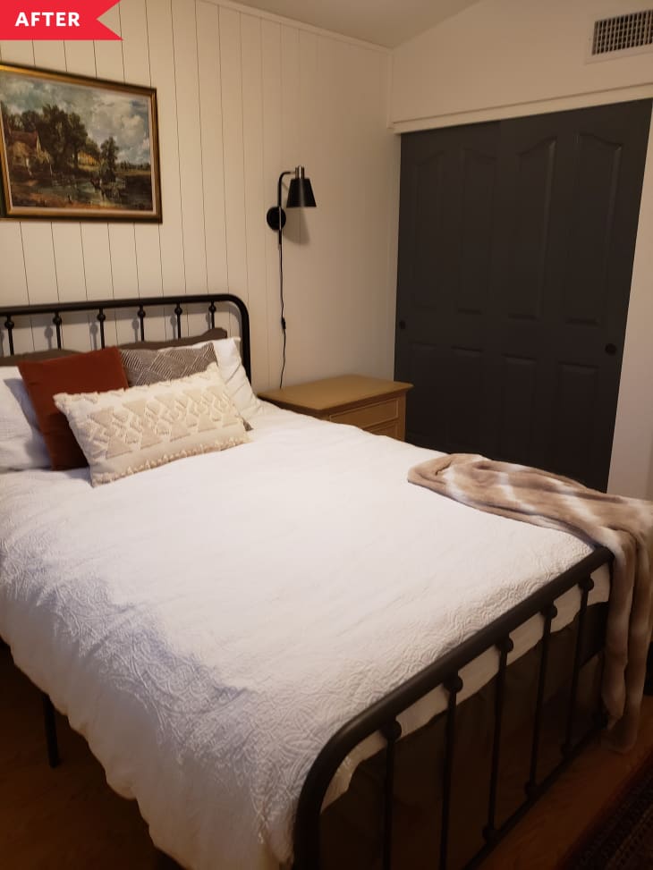 之后：卧室配有垂直的白色涂漆木镶板，农舍式的铁床框架和黑色插件kconces