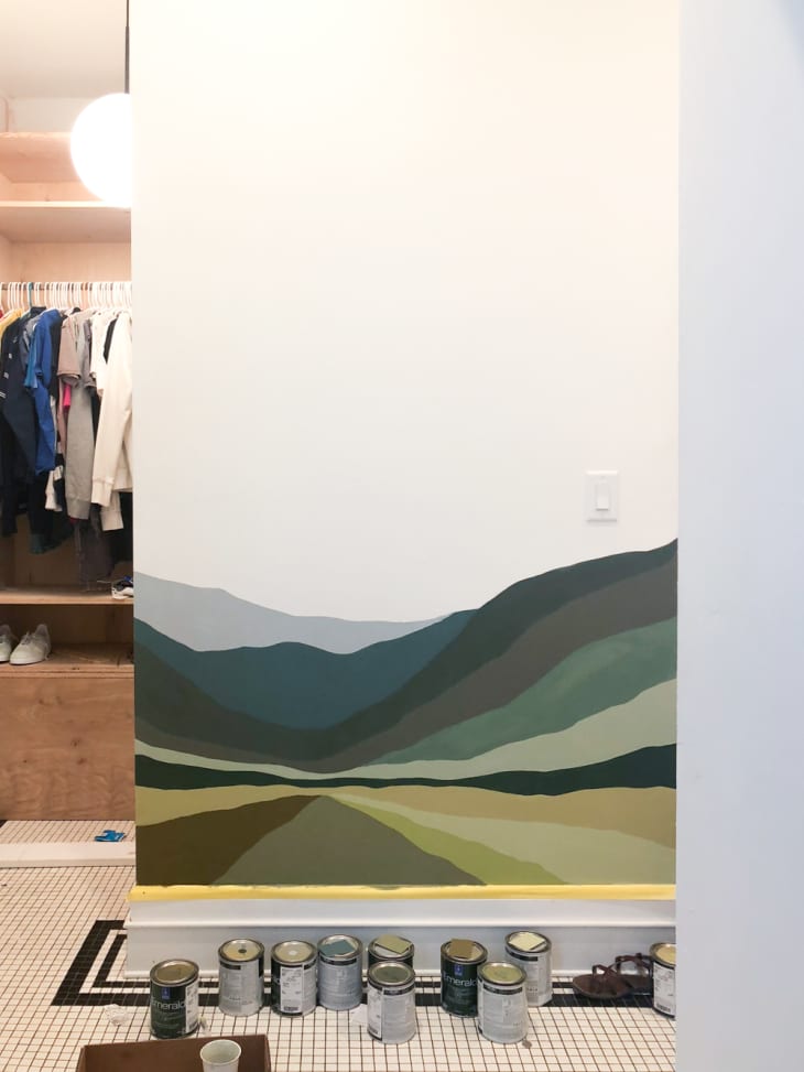 wall with a painted mural of a mountainous landscape