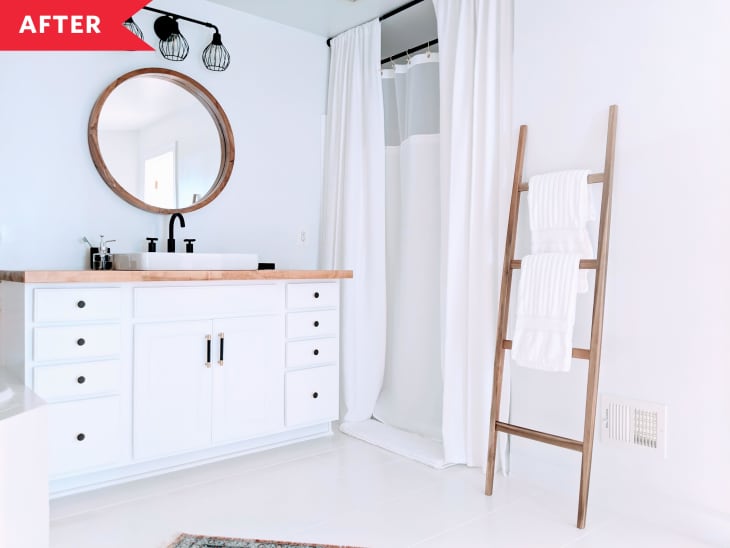 浴室装修后白色橱柜，圆镜子，白色地板