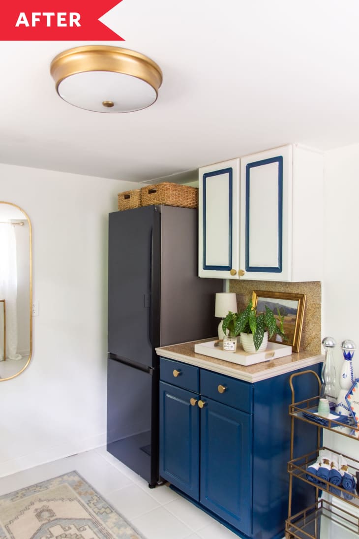 blue kitchen cabinets next to black refridgerator