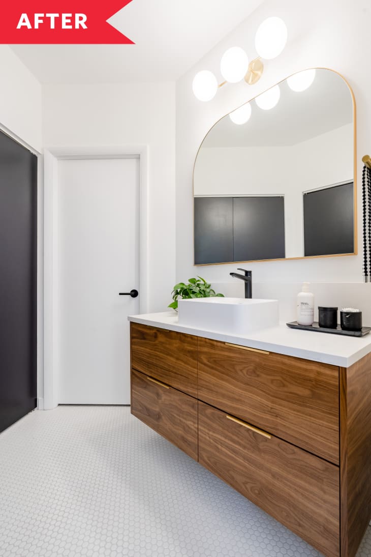 wood vanity in bathroom gold mirror white walls tile floors