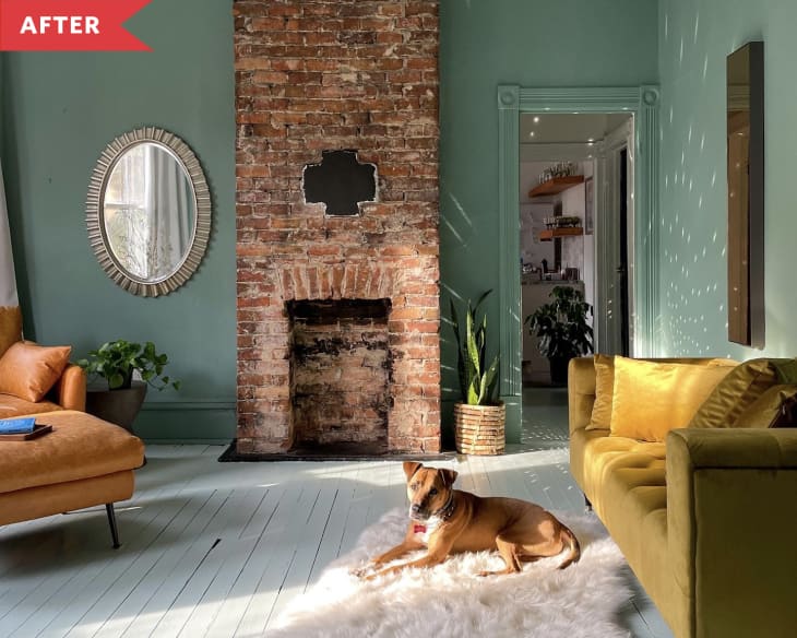 After: Living room with large brick fireplace, green walls, yellow sofa, and leather armchair